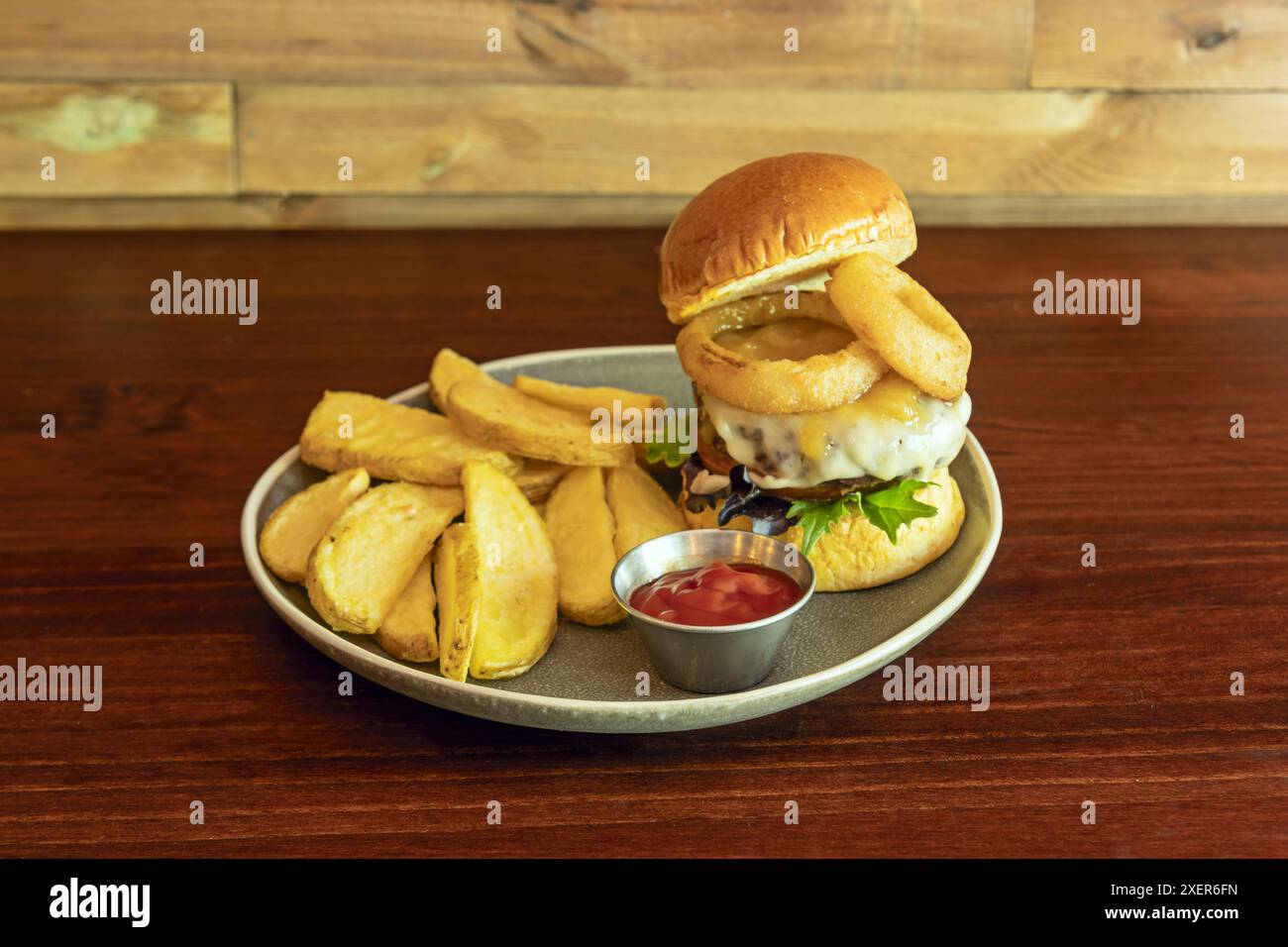 Placer la viande cuite dans le pain, ajouter les garnitures de votre choix et fermer avec le couvercle du pain. Servir avec les frites chaudes Banque D'Images