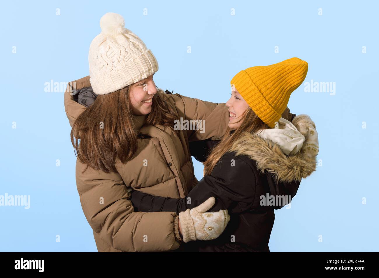 Deux filles de 10-12 ans sont heureuses de se rencontrer. Vêtements d'hiver. La rencontre tant attendue des amis. Hiver Banque D'Images