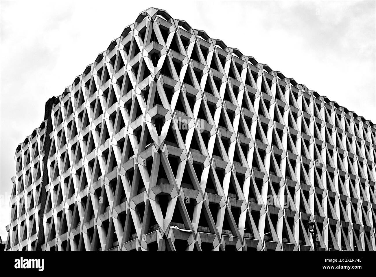 Photo en noir et blanc d'un bâtiment brutaliste en béton avec des motifs triangulaires répétés, mettant en valeur une architecture et une géométrie modernistes audacieuses Banque D'Images