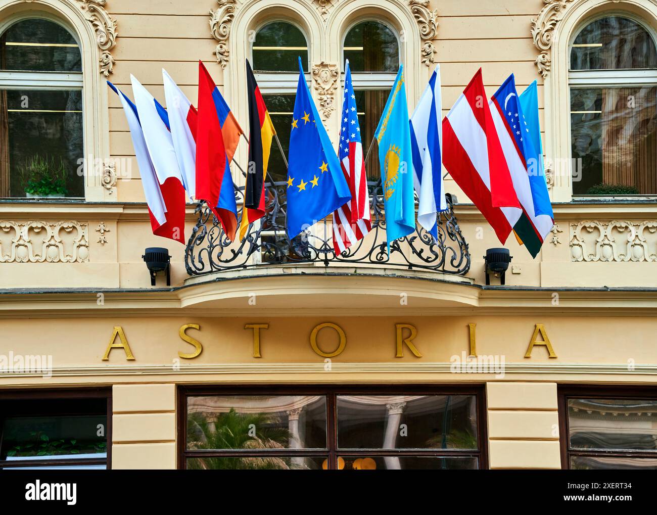 Karlsbad, Tchéquie, 10 juin 2024 : drapeaux colorés de différentes Nations et de l'UE au-dessus de l'entrée de l'Hôtel Astoria à Karlovy Vary Banque D'Images