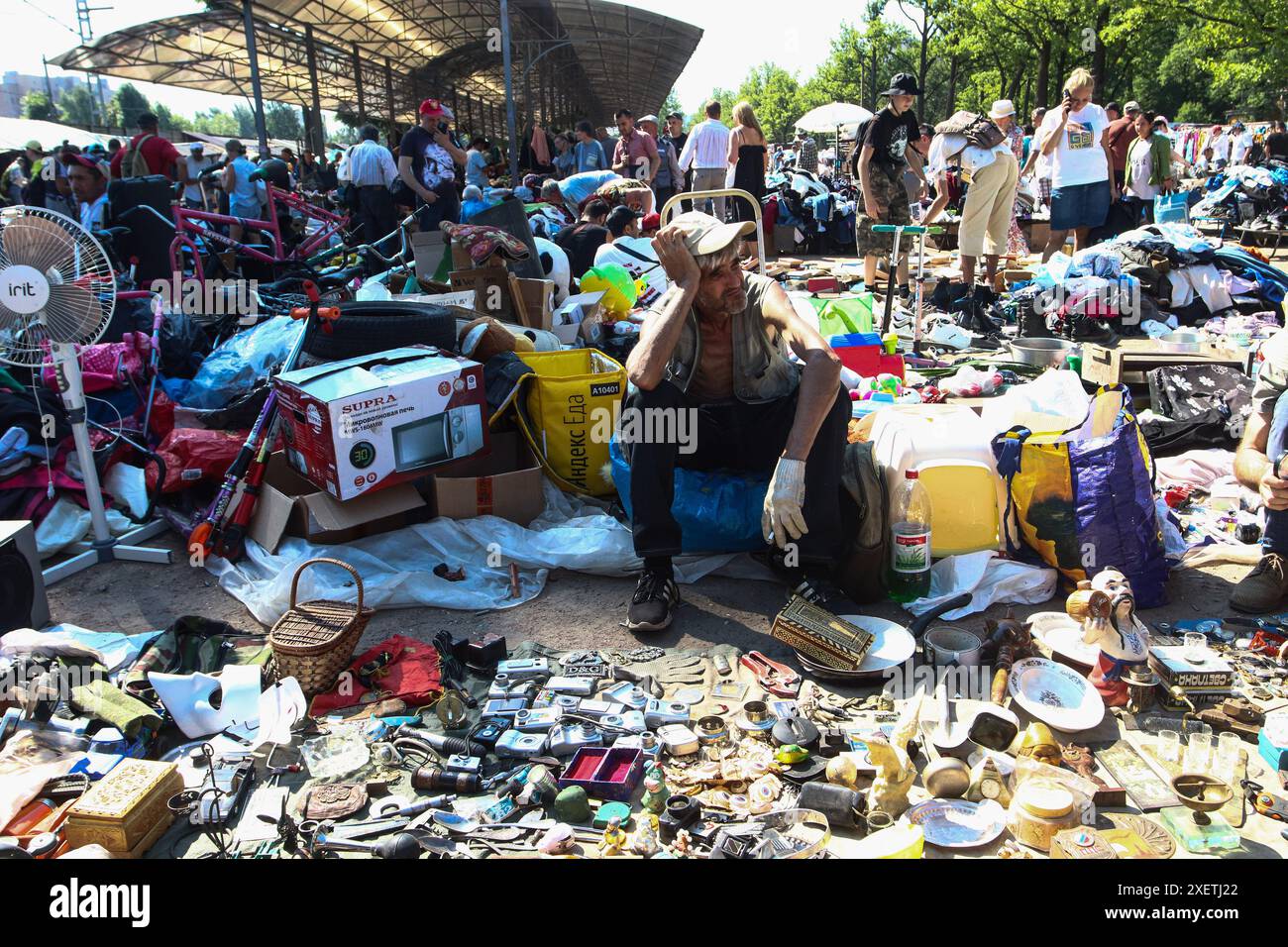 Pétersbourg, Russie. 29 juin 2024. Un vendeur masculin est assis parmi une pile de divers articles à vendre au marché aux puces Udelnaya à Pétersbourg. (Photo par Artem Priakhin/SOPA images/SIPA USA) crédit : SIPA USA/Alamy Live News Banque D'Images