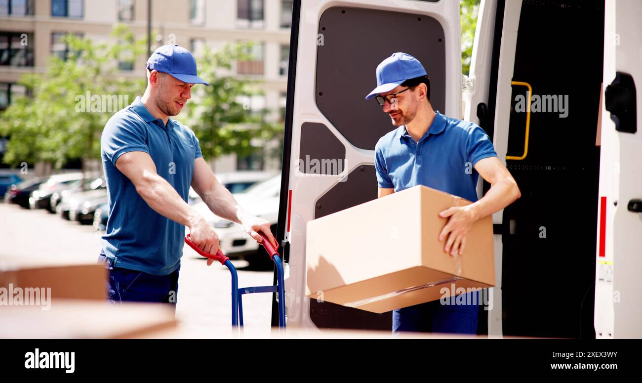 Relocalisation efficace de l'approvisionnement d'entrepôt par des hommes de livraison souriants : la logistique de la chaîne d'affaires en action avec le déchargement de la cargaison du camion Banque D'Images