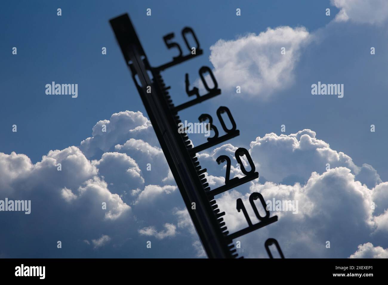 Image de symbole d'avertissement de chaleur/tempête : thermomètre devant les nuages cumulus du bâtiment (composition) Banque D'Images