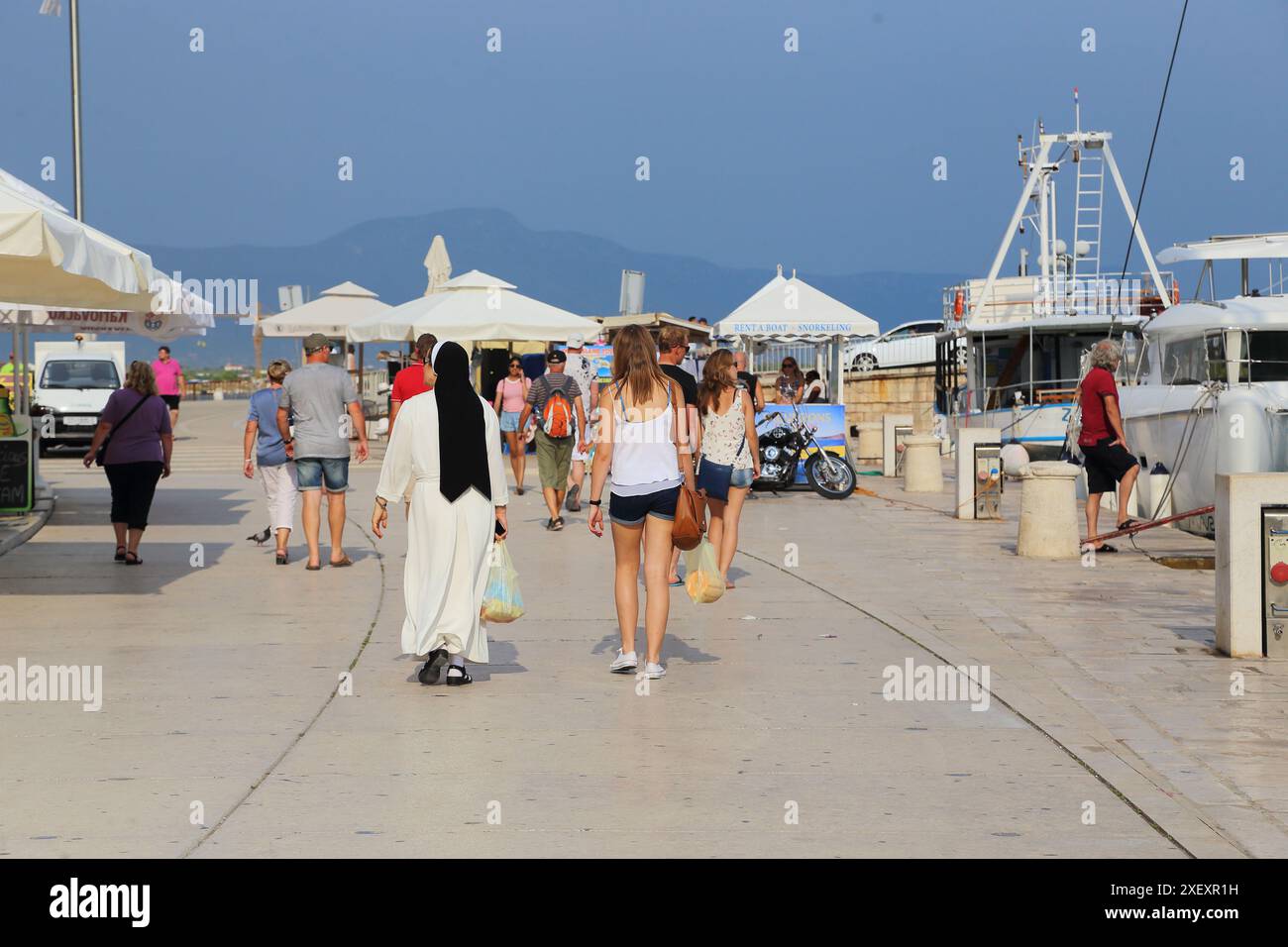 TROGIR, CROATIE - 11 SEPTEMBRE 2017 : une jeune femme non identifiée et une religieuse marchent ensemble sur le remblai de la ville. Banque D'Images