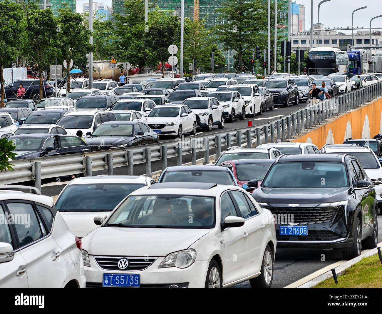 (240630) -- SHENZHEN, 30 juin 2024 (Xinhua) -- des véhicules font la queue pour passer devant une station de péage de la liaison Shenzhen-Zhongshan dans la province du Guangdong, dans le sud de la Chine, 30 juin 2024. La liaison Shenzhen-Zhongshan, un méga passage maritime dans le sud de la Chine qui comprend deux ponts, deux îles artificielles et un tunnel sous-marin, a ouvert à la circulation à 15 heures dimanche. S'étendant sur 24 km, la liaison réduit considérablement le temps de trajet entre la ville de Zhongshan et le centre technologique de Shenzhen, situé sur les côtés opposés de l'estuaire de la rivière des perles dans la province du Guangdong, réduisant ainsi la durée du voyage de deux Banque D'Images