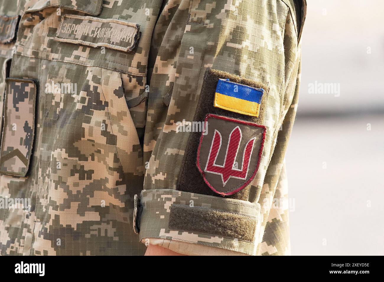 Soldat ukrainien dans l'armée et drapeau, armoiries avec un trident d'or sur un fond d'uniforme militaire. Forces armées ukrainiennes. Inscription sur t Banque D'Images