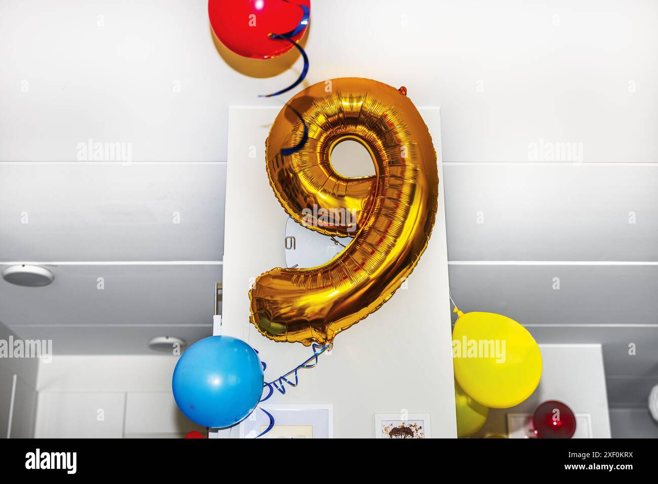 Vue rapprochée du ballon en forme de numéro neuf, rempli d'hélium, flottant à l'intérieur pour célébrer l'anniversaire de l'enfant. Banque D'Images