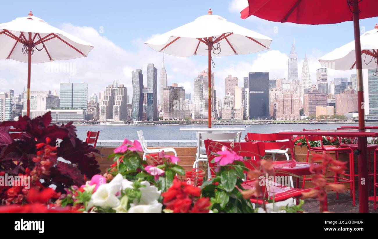 New York City Waterfront skyline, Manhattan Midtown bâtiments, gratte-ciel au bord de la rivière, des parasols de café près de l'eau East River. Paysage urbain au bord de l'eau de Hunters point, long Island, Queens, États-Unis. Banque D'Images