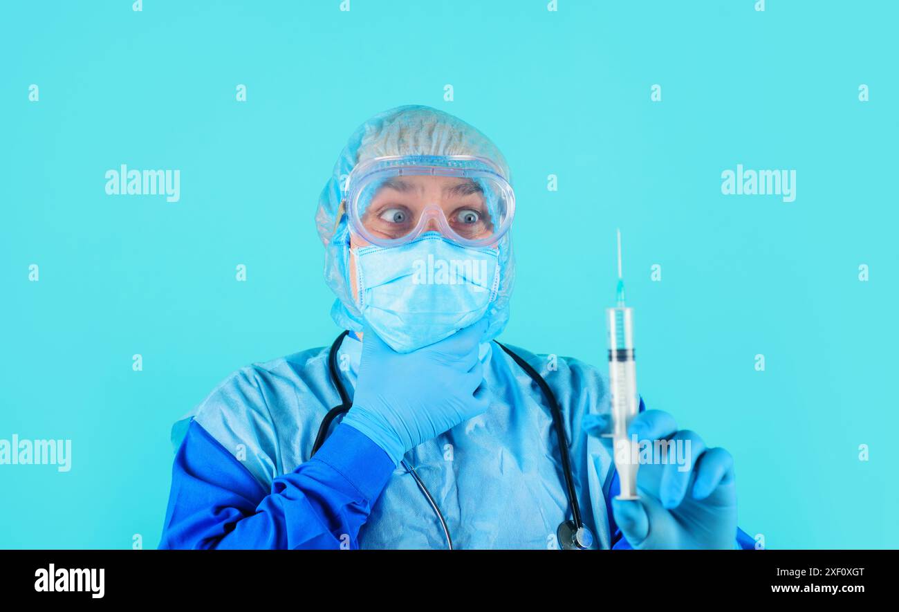 Docteur en manteau médical et gants en caoutchouc avec seringue à la main. Infirmier préparant l'injection avec le vaccin. Médecin en lunettes, bonnet chirurgical et Med Banque D'Images
