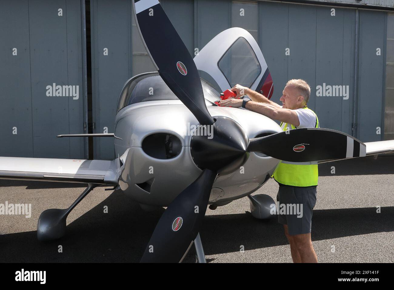 Un ingénieur aéronautique ajoute de l'huile à un monoplan Cirrus SR22 Banque D'Images
