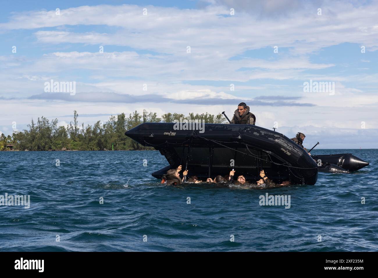Un soldat français et des Marines américains avec la 1re division des Marines retournent un engin de combat en caoutchouc lors d'un cours de commando dans le cadre de Marara 24 à Tahiti, Polynésie française, le 7 juin 2024. Marara est un exercice d’entraînement multinational qui améliore l’interopérabilité combinée entre l’armée américaine et le quartier général de la Force opérationnelle interarmées française en Polynésie française. La formation fait progresser les capacités des partenaires à faire face aux imprévus complexes et futurs dans l’ensemble de l’Indo-Pacifique. (Photo du corps des Marines des États-Unis par le caporal Willow Marshall) Banque D'Images