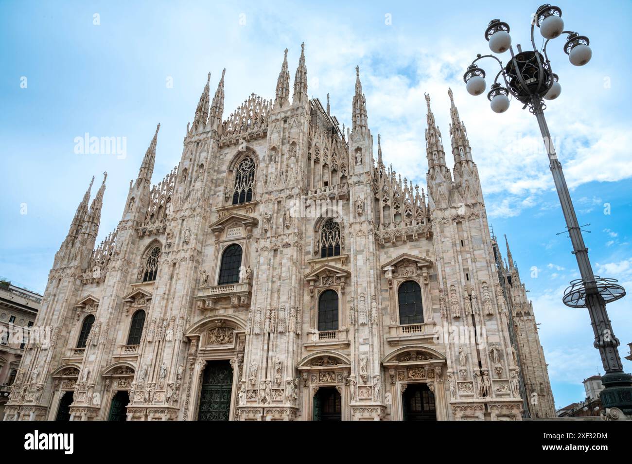 La façade du Duomo di Milano, ou cathédrale de Milan, s'élève au-dessus du spectateur avec ses nombreuses flèches et détails Banque D'Images