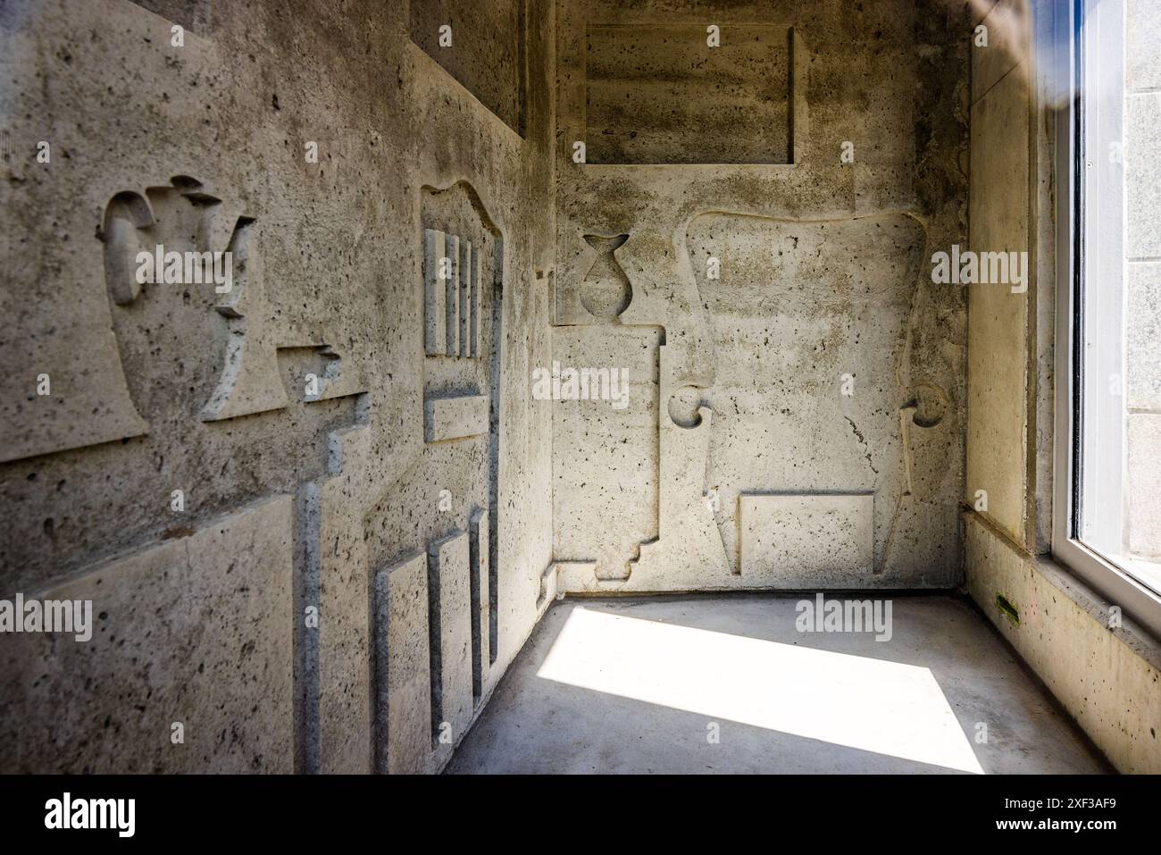 Deux panneaux de béton de trois mètres de haut sont suspendus dans la salle en forme de puits du mémorial de l’aryanisation sur la Weserpromenade à Brême, leurs surfaces portant l’empreinte ombragée de meubles. Conçu par Evin Oettingshausen, le mémorial commémore depuis 2023 l’expropriation et le vol systématiques des citoyens juifs sous le nazisme. Il se dresse là où les navires déchargeaient autrefois des meubles et des biens pillés d’Europe occidentale occupée à Brême. Straße Tiefer, angle de la Wilhelm-Kaisen-Brücke, Brême, Allemagne. Banque D'Images