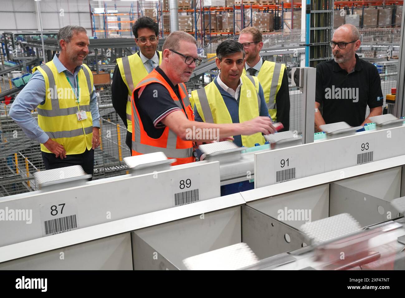 Le premier ministre Rishi Sunak s’entretient avec le personnel lors d’une visite à Well Healthcare Supplies, un centre d’emballage et de distribution de produits pharmaceutiques à Stoke-on-Trent, dans le Staffordshire, alors qu’il est sur la piste de la campagne électorale générale. Date de la photo : lundi 1er juillet 2024. Banque D'Images