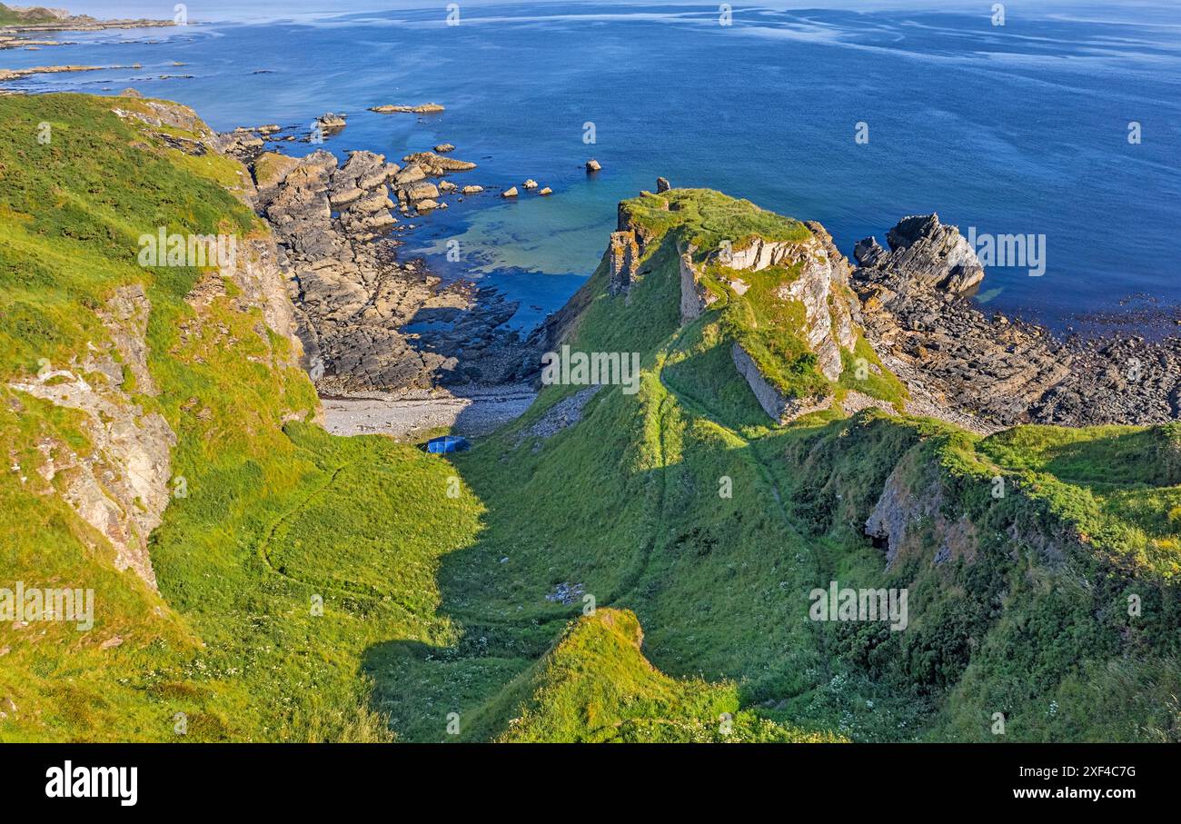 Ruines du château de Findlater Aberdeenshire Écosse début d'été matin mer calme et tente bleue camping sauvage Banque D'Images