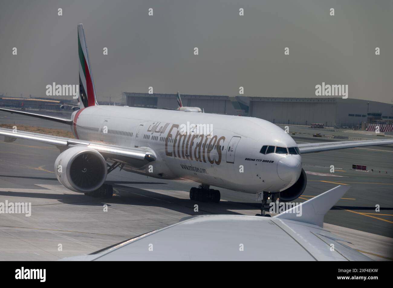 Un Boeing 777-300 er d'Emirates circulant derrière un Airbus 380 Emirates pour décoller de l'aéroport international de Dubaï aux Émirats arabes Unis Banque D'Images