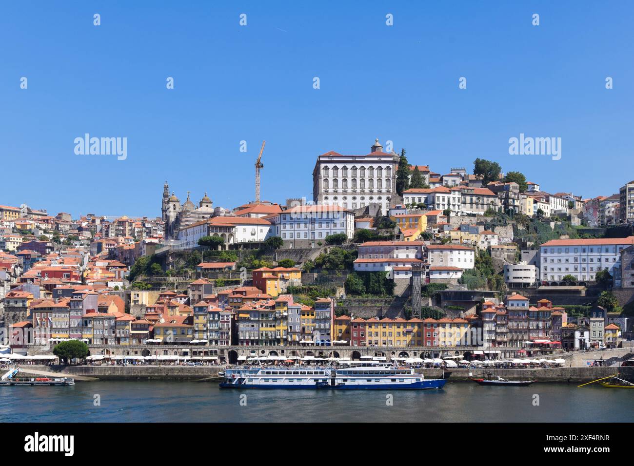 Une vue vibrante sur les bâtiments colorés de Porto le long du fleuve Douro, mettant en valeur l'architecture historique et l'atmosphère animée de cet UNESC Banque D'Images