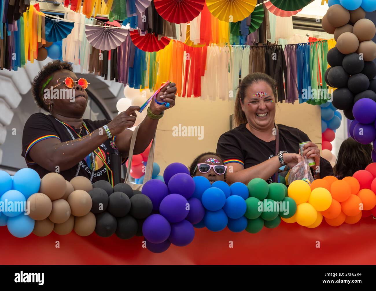 Londres / Royaume-Uni - juin 29 2024 : des femmes lesbiennes et un enfant avec des ballons à la parade annuelle Pride in London. La célébration rassemble les gens de l Banque D'Images