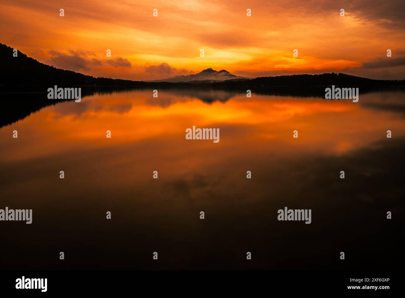 Coucher de soleil épique avec des reflets sur le lac en Bohême du nord. Moment à couper le souffle quand le soleil peint des couleurs à travers tout le ciel. Banque D'Images