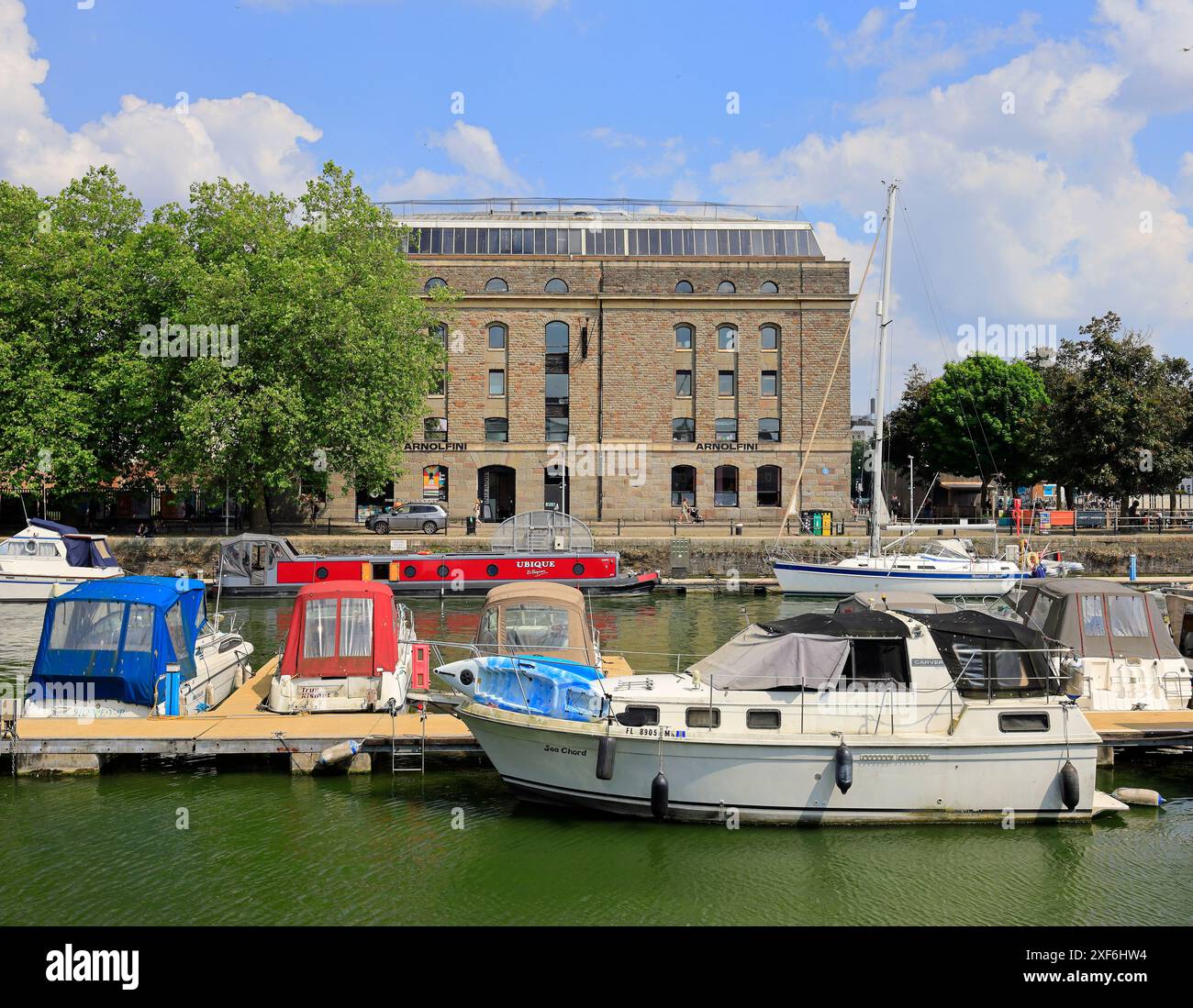 Bateaux colorés avec la galerie d'art Arnolfini bâtiment à travers le port flottant, Bristol. Prise juin / juillet 2024 Banque D'Images