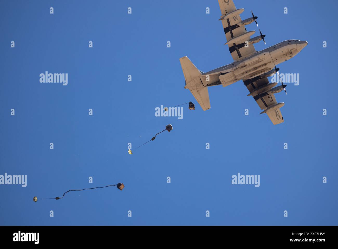 Un avion de transport KC-130J Hercules du corps des Marines des États-Unis vole au-dessus du ciel, relâchant une cargaison pour un largage aérien pendant le cours d'instructeur d'armes et de tactiques 2-24 près de Landing zone Hatch, Yuma, Arizona, le 2 avril 2024. WTI est un cours avancé qui fournit une formation tactique pour améliorer et employer des armes et tactiques d'aviation avancées. (Photo du corps des Marines des États-Unis par le caporal Hannah Hollerud) Banque D'Images