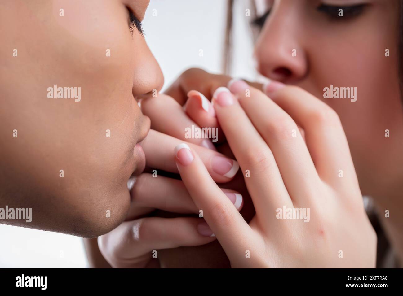 gros plan montre un couple qui s'embrasse les mains de l'autre, symbolisant l'affection profonde et le respect mutuel. Leurs doigts entrelacés et leurs gestes doux se refle Banque D'Images