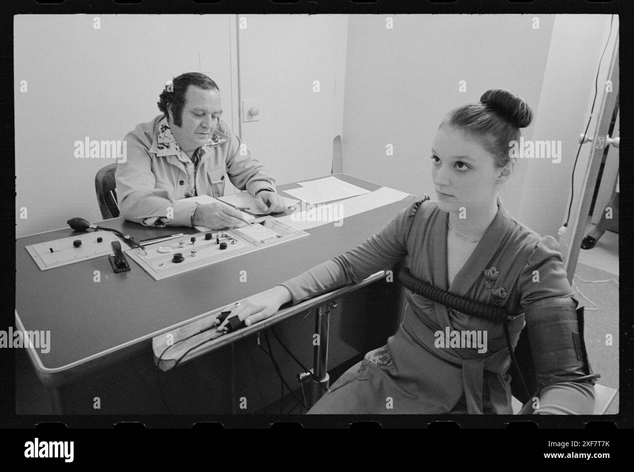 L'homme administre un test polygraphique (détecteur de mensonge) à une candidate à un emploi qui est assise dans une chaise, Washington, District de Columbia, 2/20/1976. (Photo de Thomas O'Halloran/U S News and World Report Collection Banque D'Images