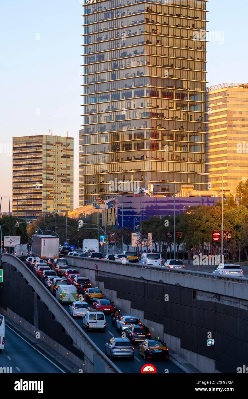 Trafic dense sur une autoroute avec des gratte-ciel modernes et des arbres en arrière-plan pendant le coucher du soleil, Hospitalet de Llobregat, Barcelone, Catalogne, Espagne Banque D'Images