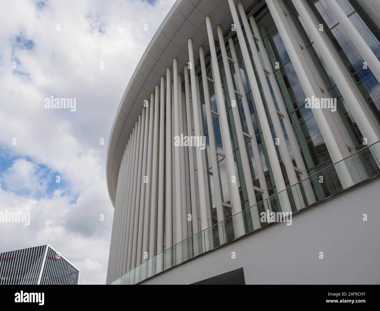 Architecture moderne avec de nombreuses baies vitrées et colonnes blanches sous un ciel nuageux, luxembourg Banque D'Images