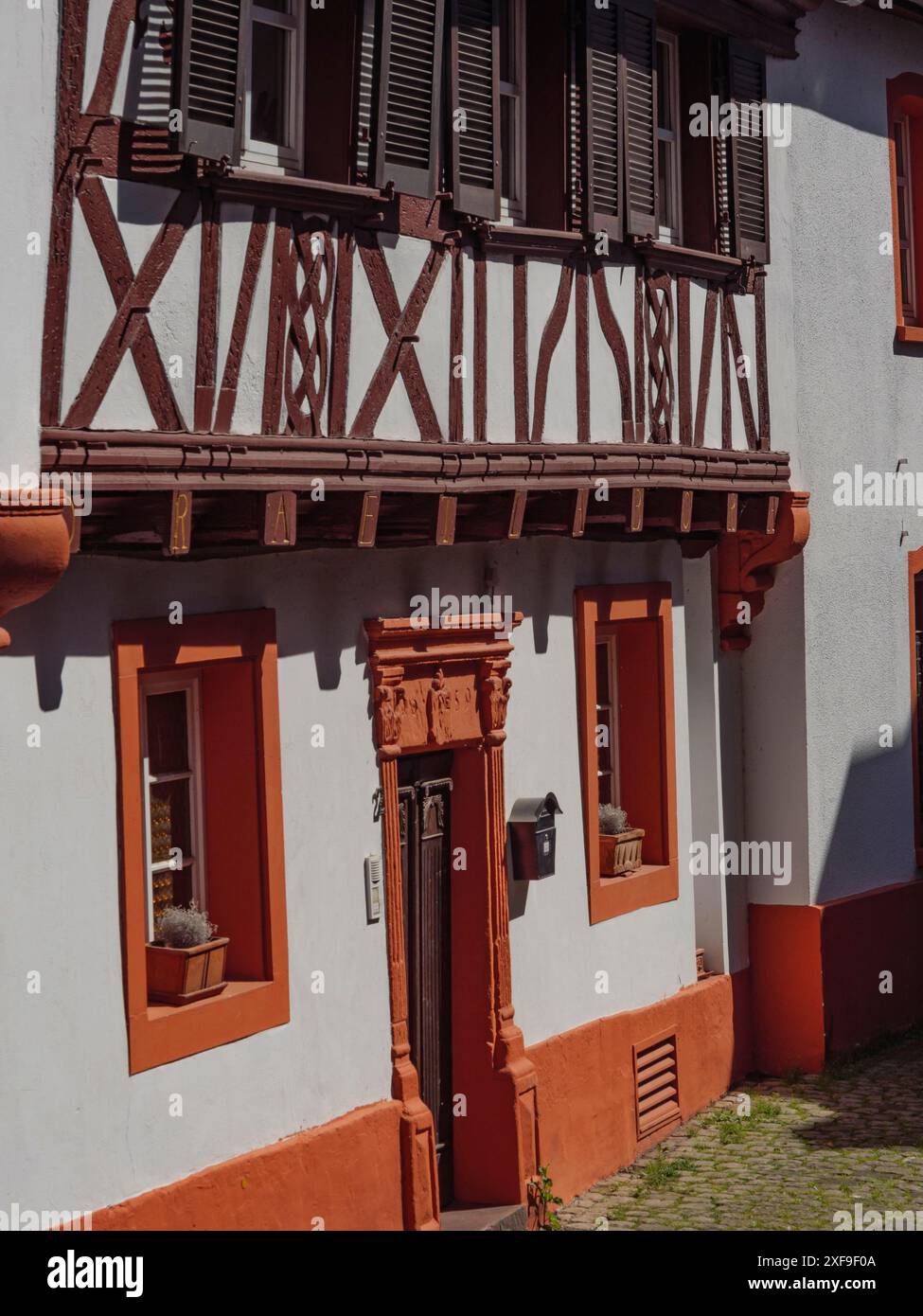 Maison à colombages avec façade orange-blanc et poutres apparentes et plusieurs fenêtres, Saarburg, Allemagne Banque D'Images