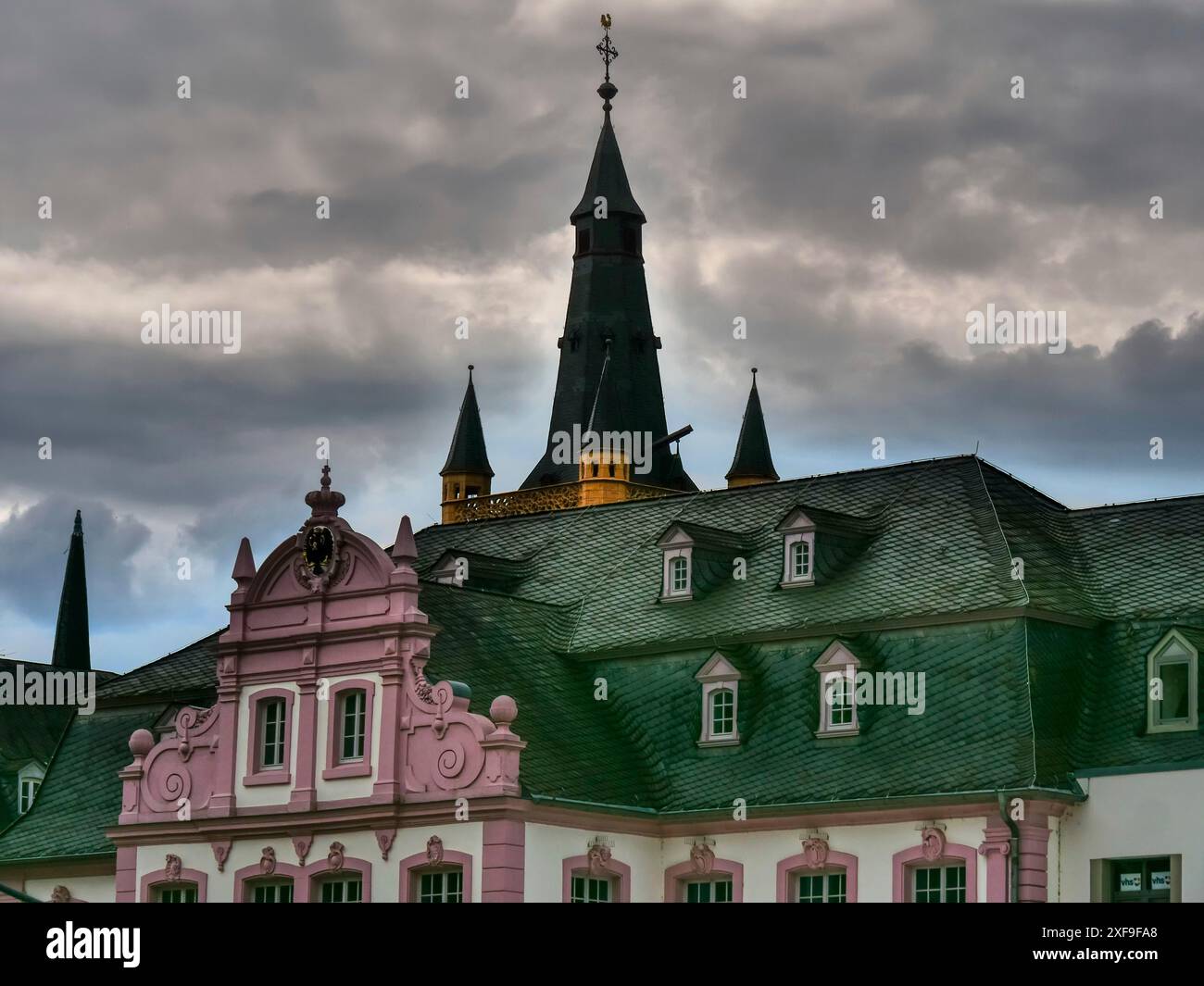 Bâtiments historiques et églises avec de hautes tours et des toits verts sous un ciel nuageux dramatique, trèves, allemagne Banque D'Images