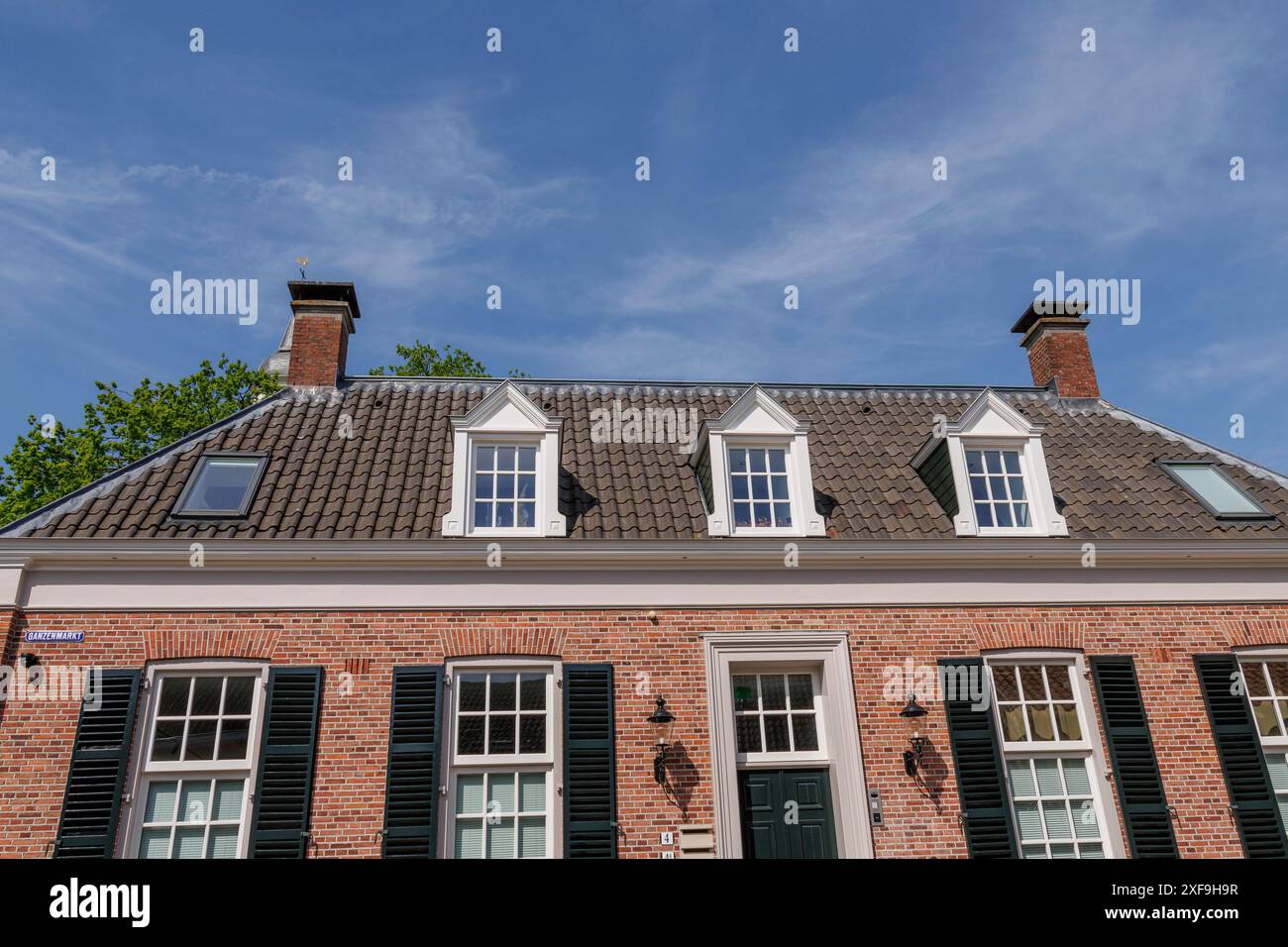 Maison classique en briques avec cheminées et fenêtres sous un ciel bleu, ootmarsum, pays-bas Banque D'Images
