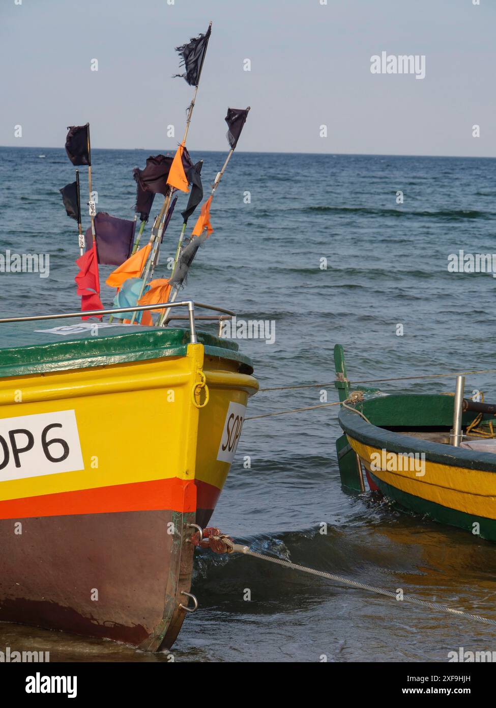 Deux bateaux de pêche avec des drapeaux hissés se tiennent dans l'eau ondulée sur la plage, sopot, mer baltique, pologne Banque D'Images