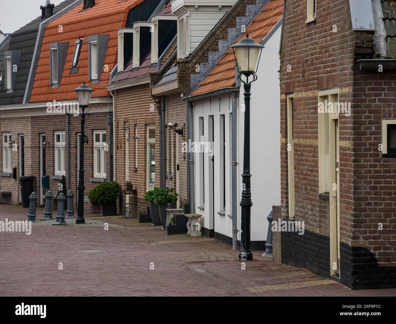 Ruelle étroite dans un village avec des pavés, aux bords sont des maisons en briques confortables, urk, pays-bas Banque D'Images