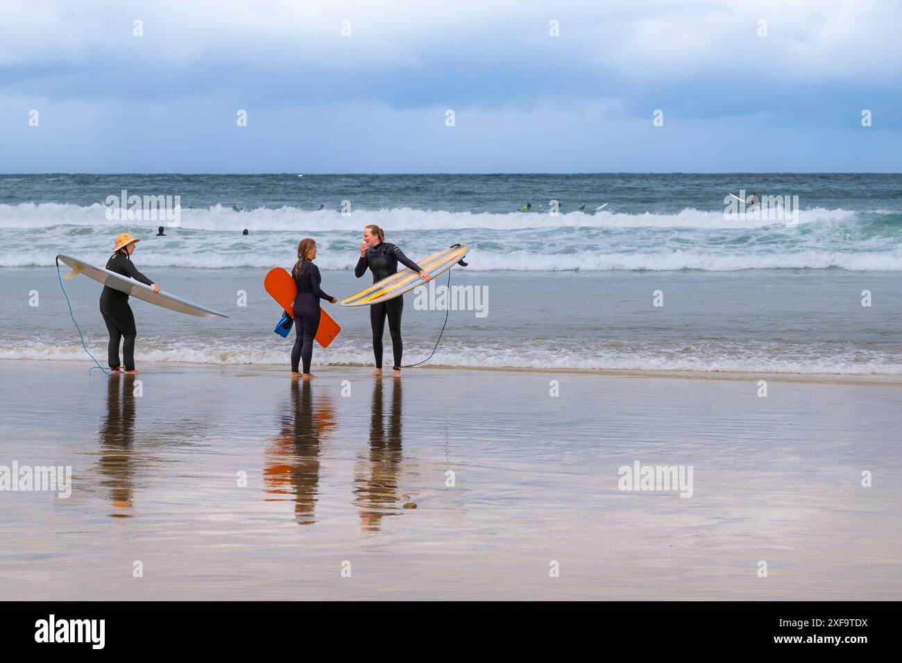 Surfeurs debout sur le rivage discutant à GT Great Western Beach à Newquay en Cornouailles au Royaume-Uni. Banque D'Images Surfeurs debout sur le rivage discutant à GT Great Western Beach à Newquay en Cornouailles au Royaume-Uni. Banque D'Images