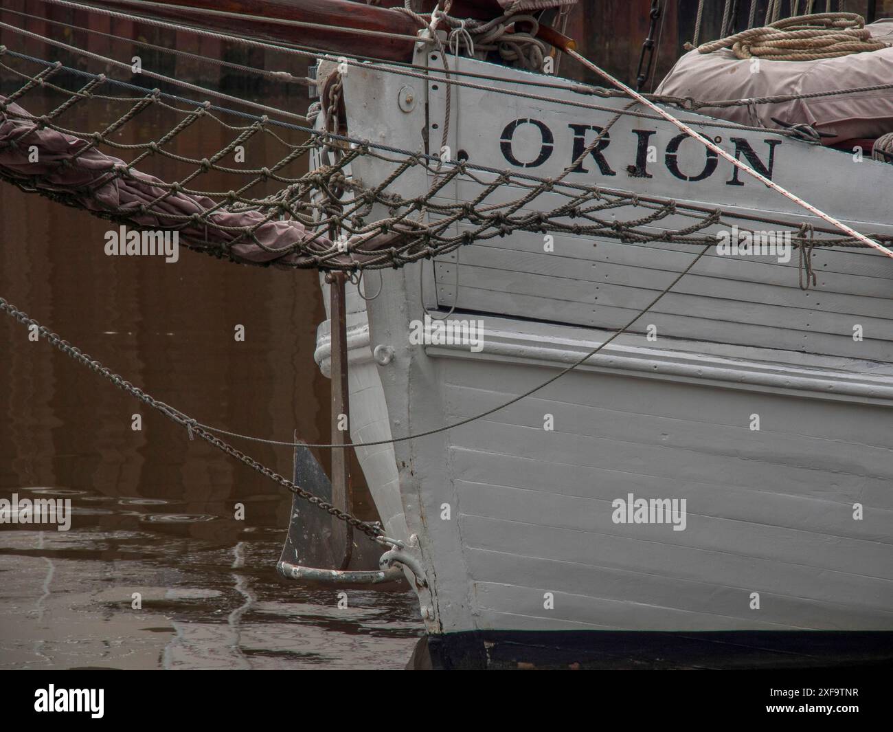 Gros plan de la proue blanche d'un bateau nommé Orion avec des cordes et de l'eau en arrière-plan, carolinensiel, allemagne Banque D'Images