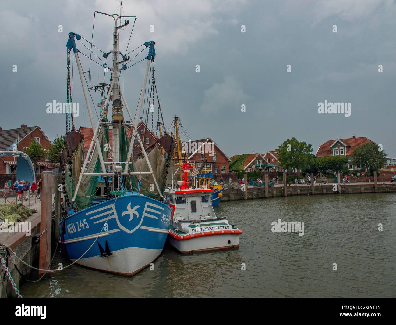 Grands navires dans le port sous un ciel nuageux et entouré de maisons côtières, carolinensiel, allemagne Banque D'Images