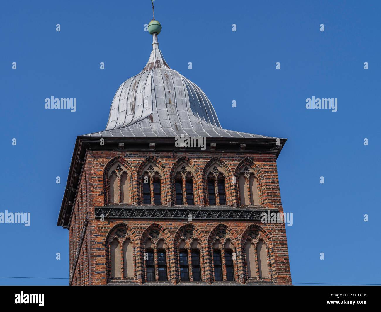Tour historique avec toit en métal pointu et fenêtres décoratives sur un ciel bleu, Luebeck, mer Baltique, Allemagne Banque D'Images