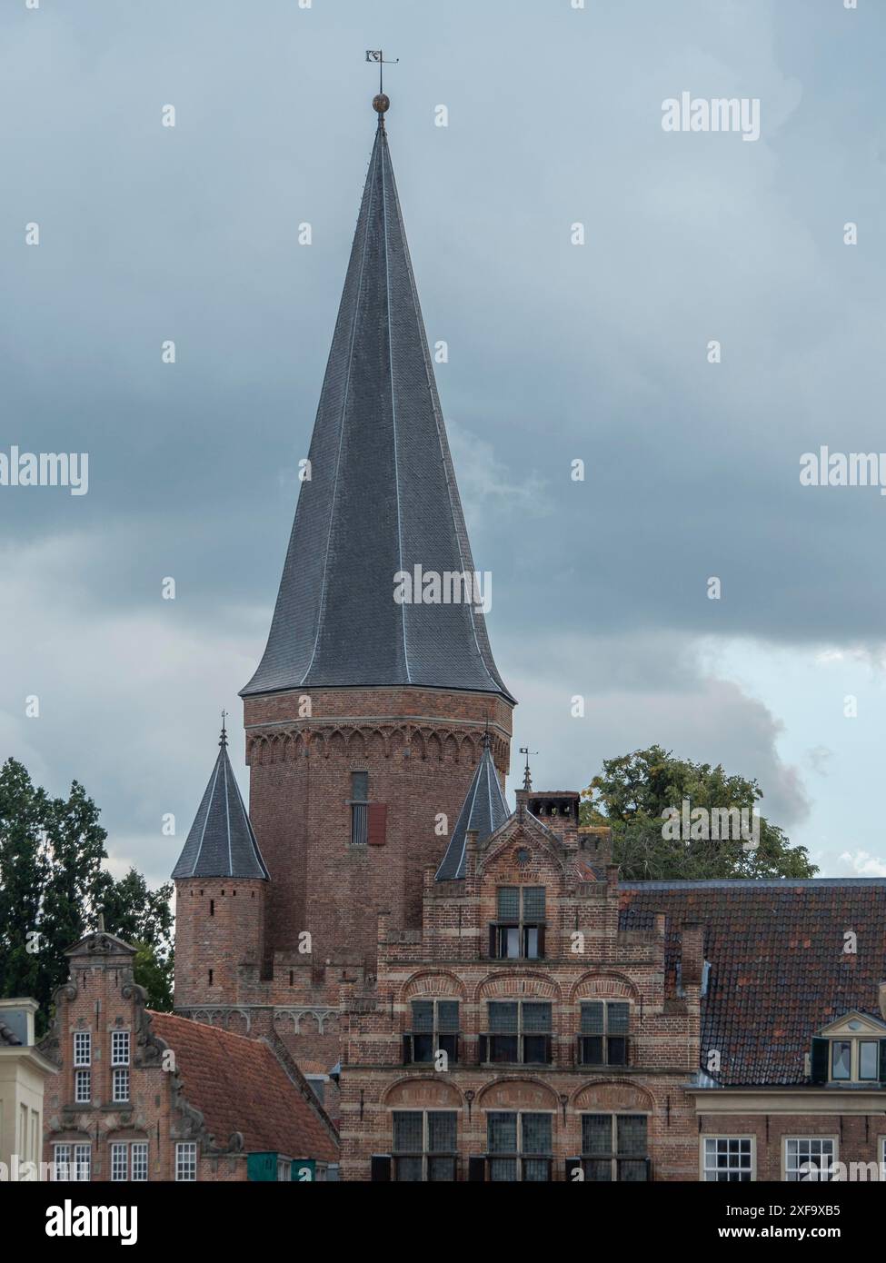 Une tour de château médiévale entourée de maisons historiques sous un ciel nuageux, zutphen, pays-Bas Banque D'Images