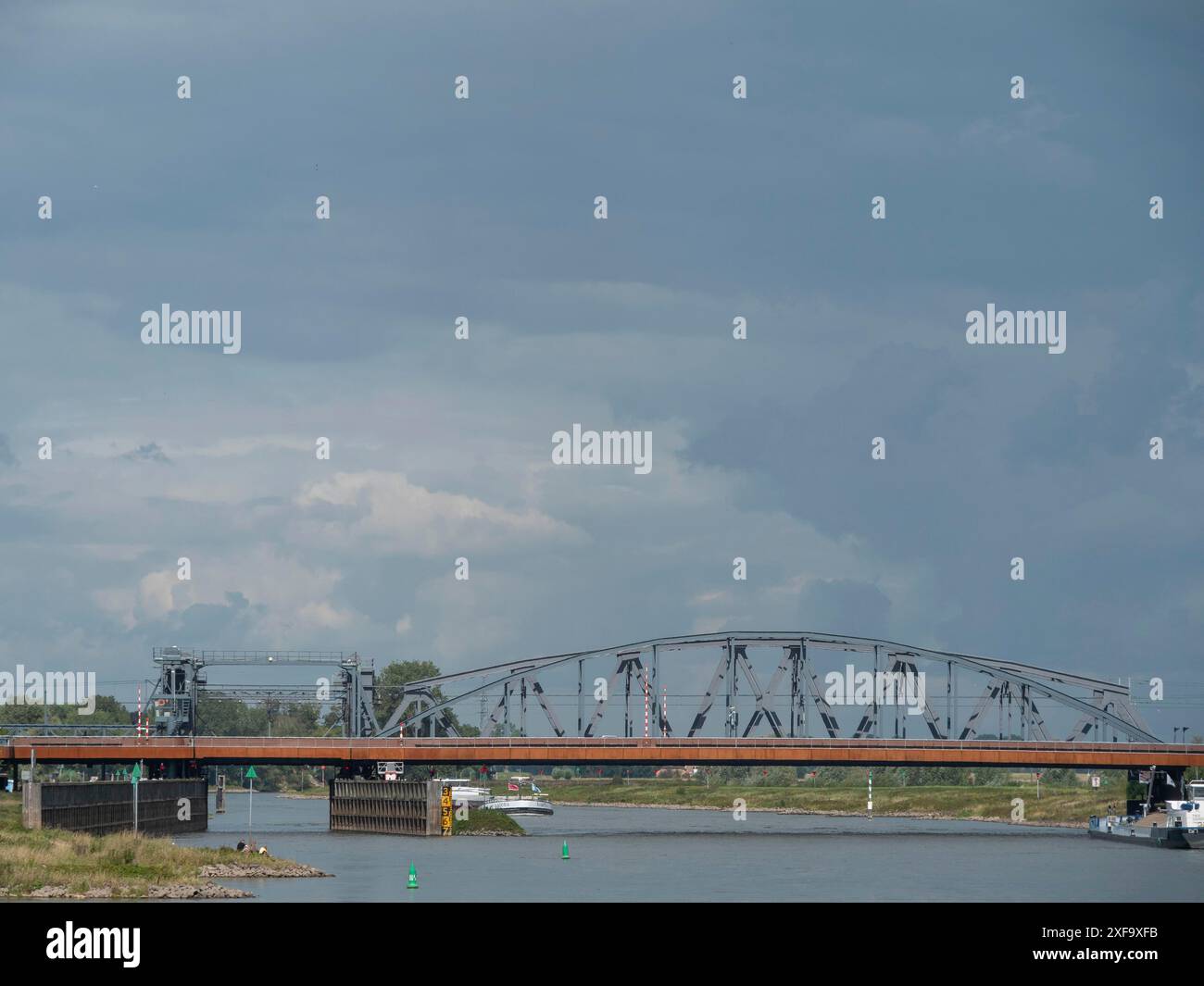 Un pont en acier enjambant une rivière sous un ciel nuageux, zutphen, pays-Bas Banque D'Images