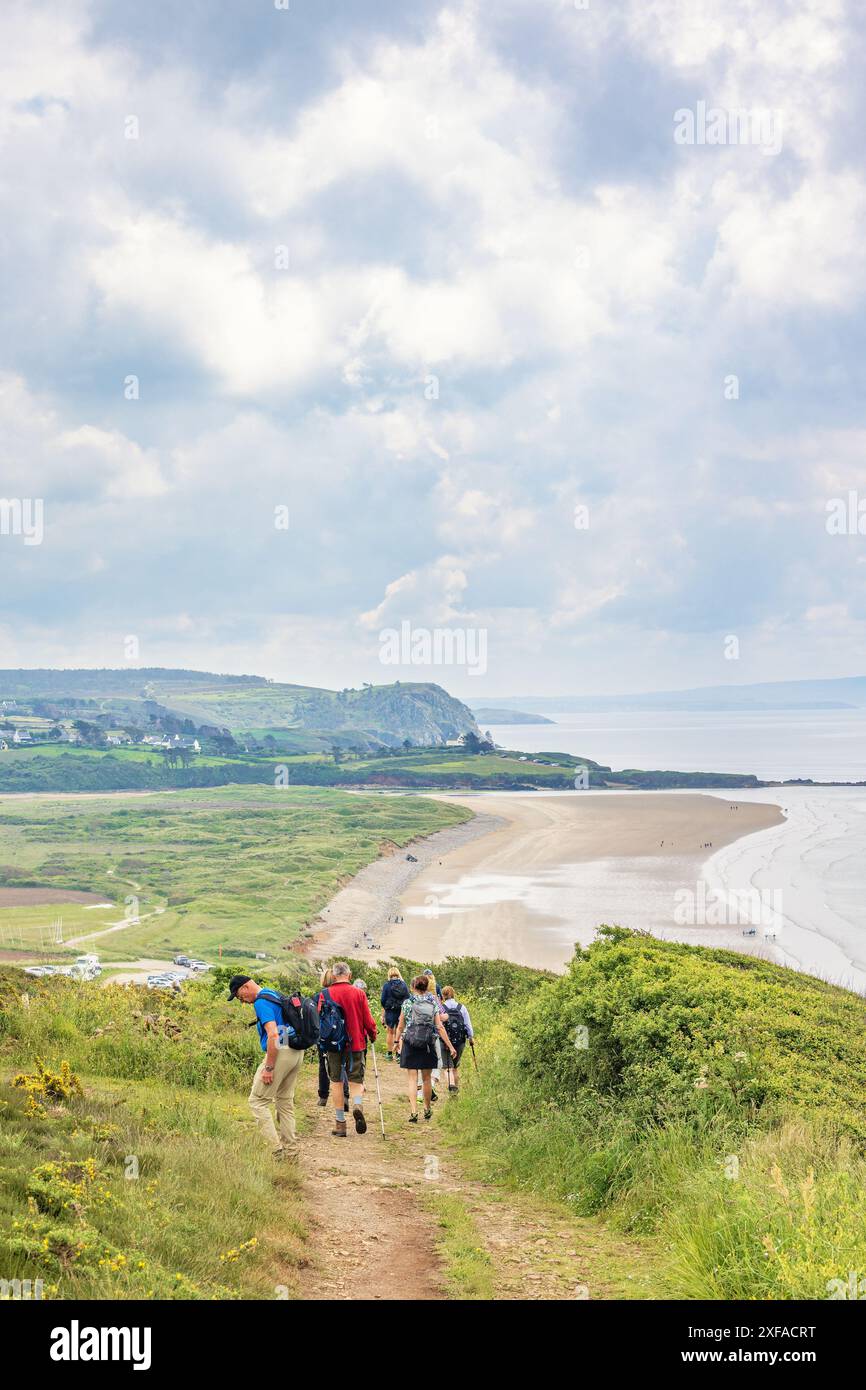 Groupe de randonneurs marchant sur un chemin dans un beau paysage côtier Banque D'Images