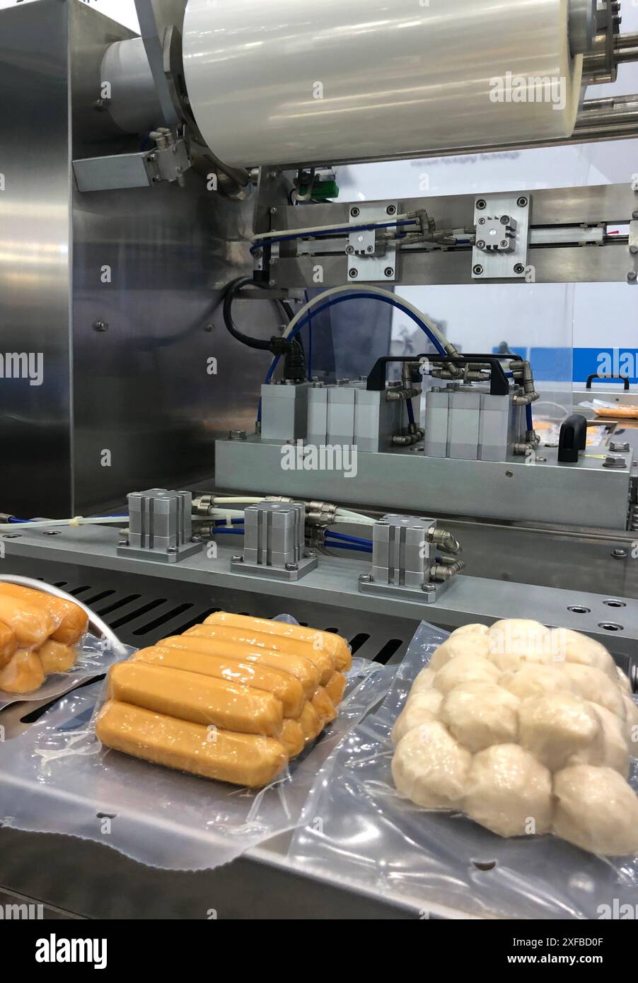 Les machines à haute performance emballent des produits alimentaires frais transformés, des saucisses en boulettes de viande.lignes de production alimentaire sur des bandes transporteuses, indus de production alimentaire Banque D'Images