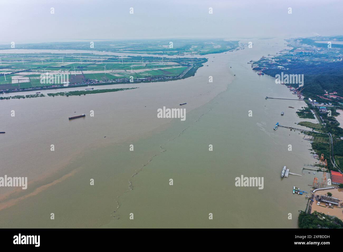 Jiujiang. 2 juillet 2024. Une photo de drone aérien prise le 2 juillet 2024 montre la confluence du lac Poyang (R) et du fleuve Yangtze dans le comté de Hukou, dans la province du Jiangxi, à l'est de la Chine. Le niveau d'eau à la station hydrologique de Xingzi du lac Poyang avait atteint 21,29 mètres à 20 heures mardi, 2,29 mètres au-dessus du point d'alerte. Crédit : Zhou Mi/Xinhua/Alamy Live News Banque D'Images
