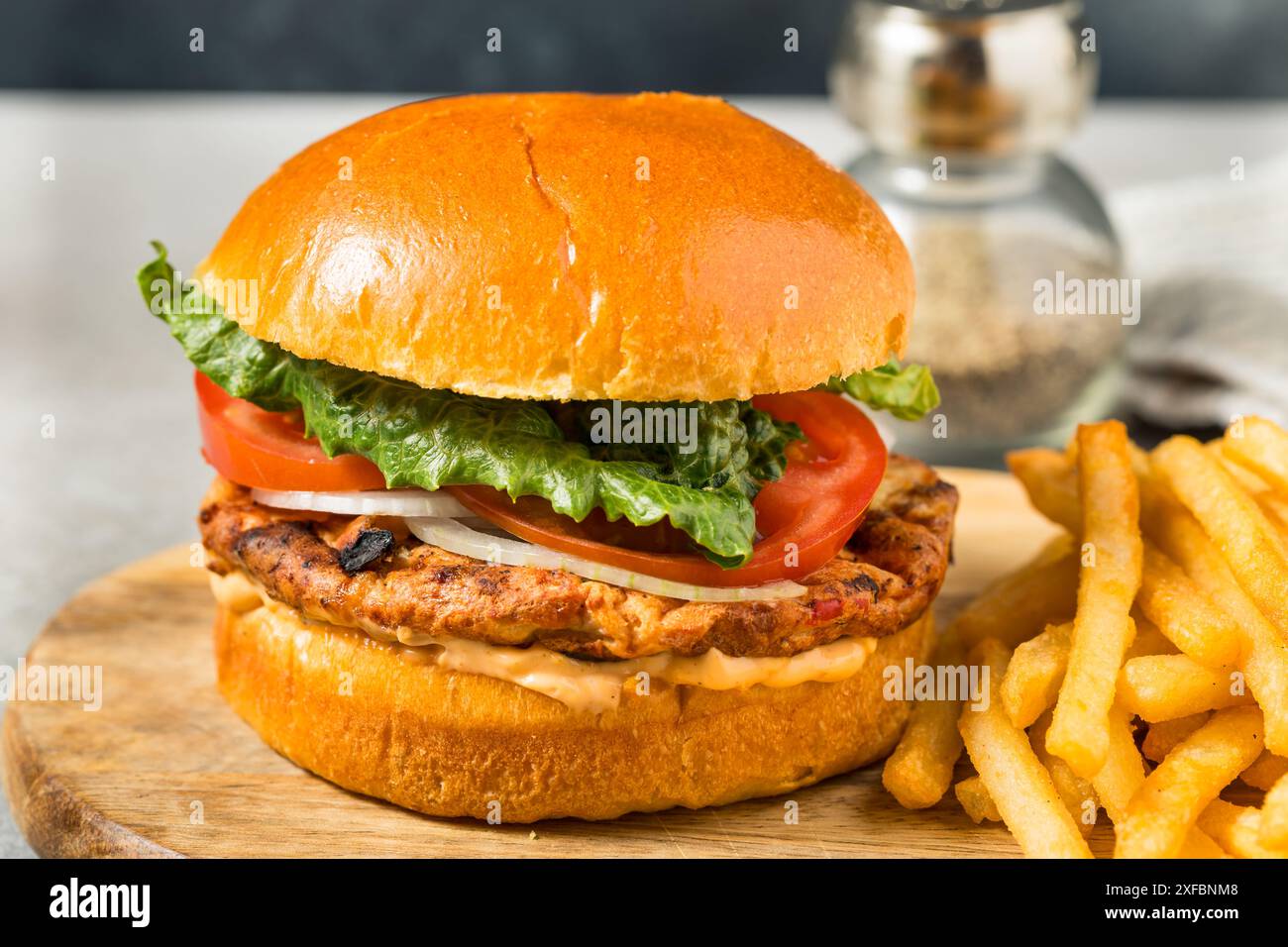 Hamburger de poulet grillé au chipotle avec tomates oignons et laitue Banque D'Images