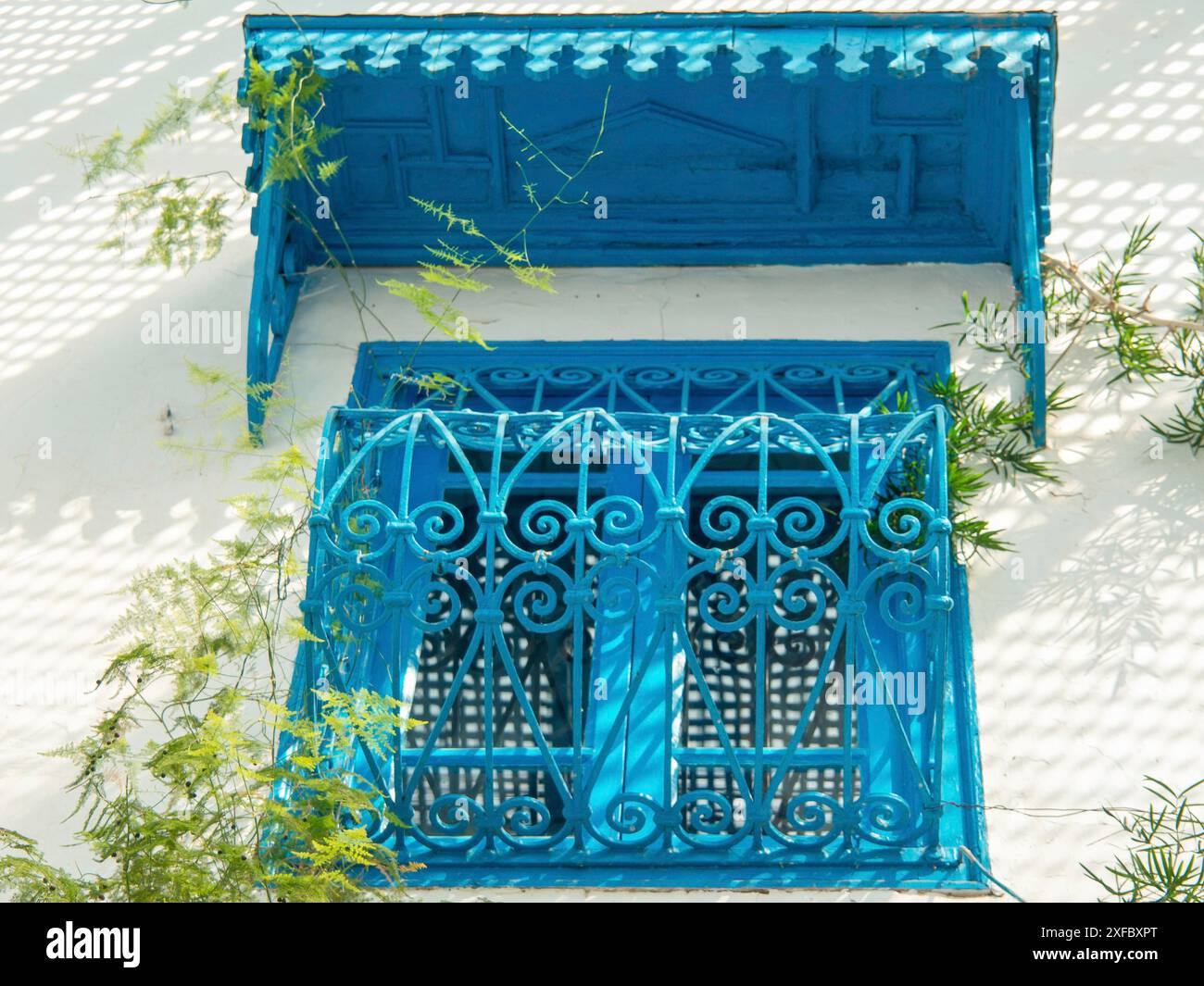 Fenêtre bleue avec décorations sur une maison blanchie à la chaux, Tunis, Tunisie Banque D'Images