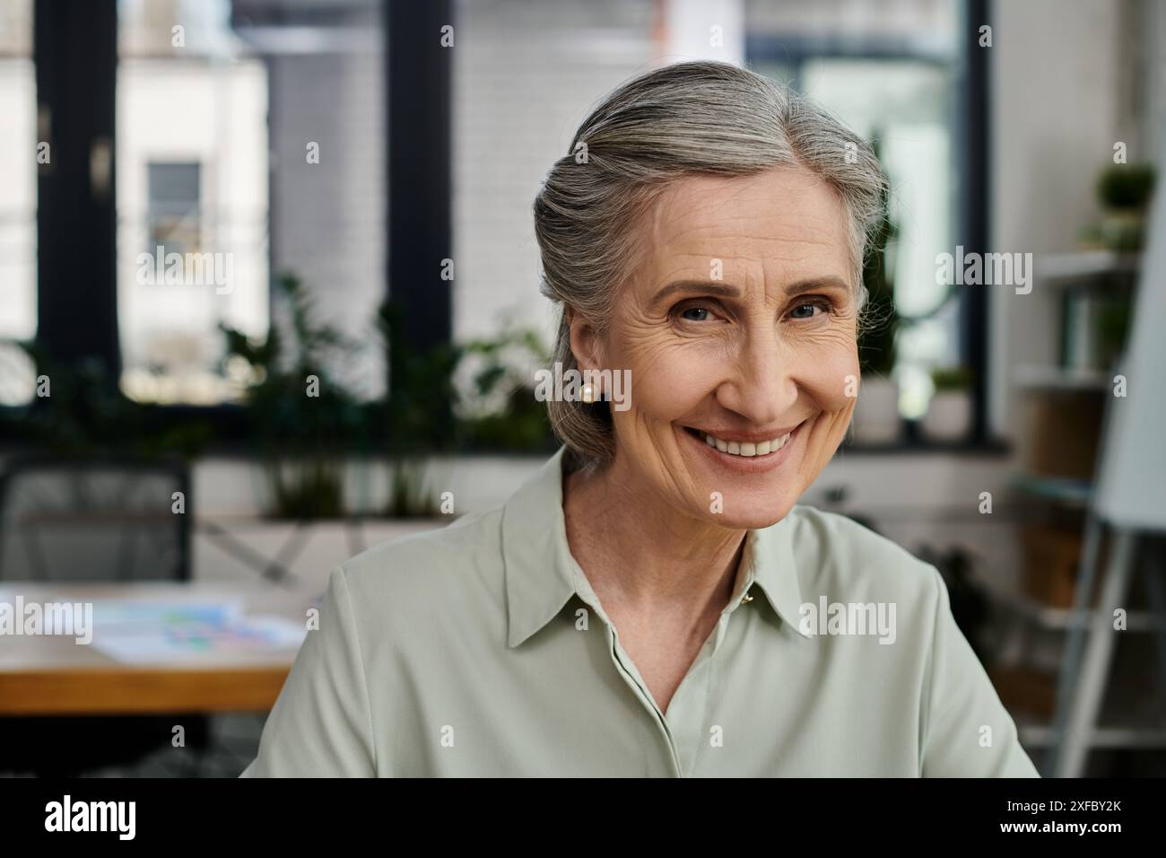 Une femme âgée dans un bureau contemporain. Banque D'Images