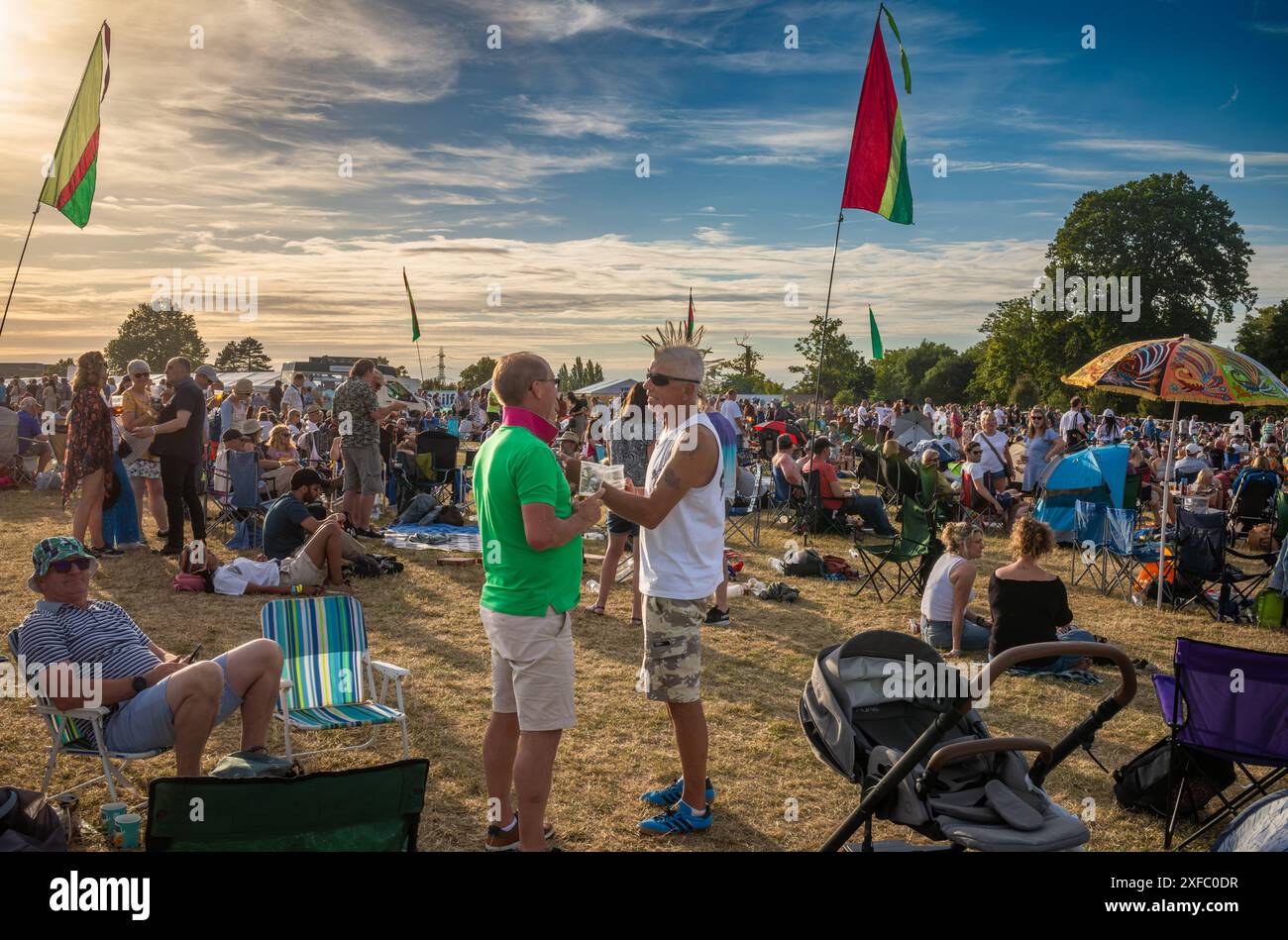 Guildford / UK - juin 29 2024 : un vieux rocker punk avec une coiffure mohican et d'autres festivaliers au festival de musique Guilfest, Guildford, Surrey, Royaume-Uni. Banque D'Images