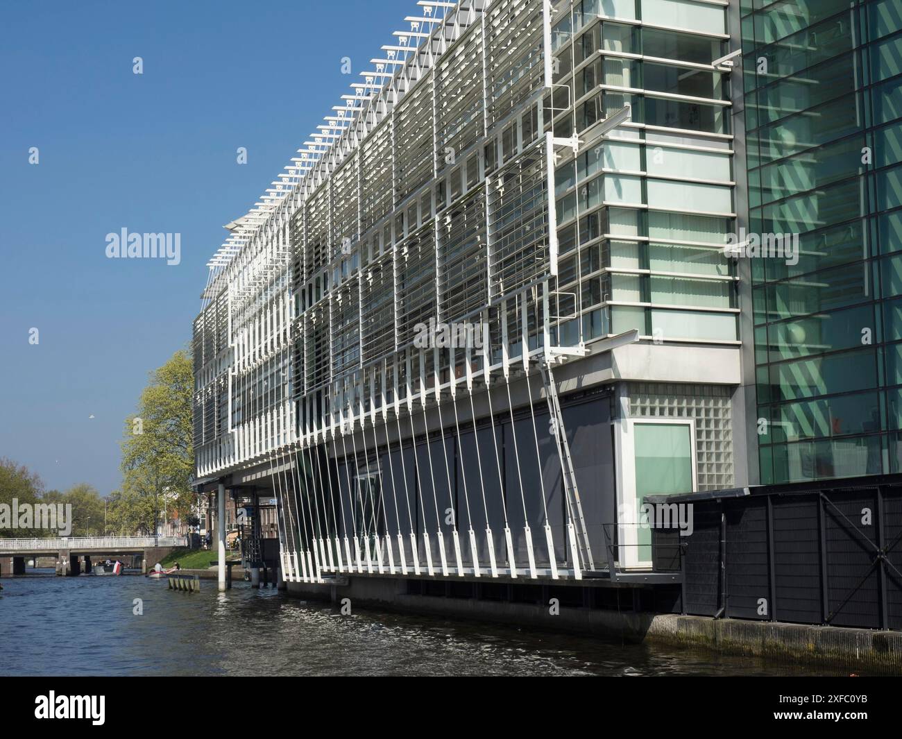 Complexe moderne de construction en verre et en acier près d'un canal par une journée claire et ensoleillée, haarlem, pays-Bas Banque D'Images