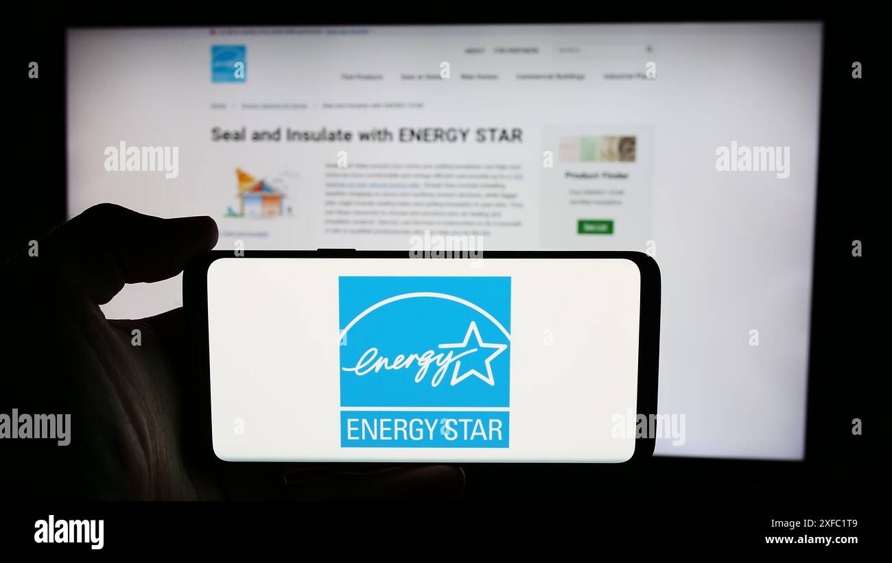 Personne tenant un téléphone portable avec le logo du programme américain d'efficacité énergétique Energy Star devant la page Web. Concentrez-vous sur l'affichage du téléphone. Banque D'Images
