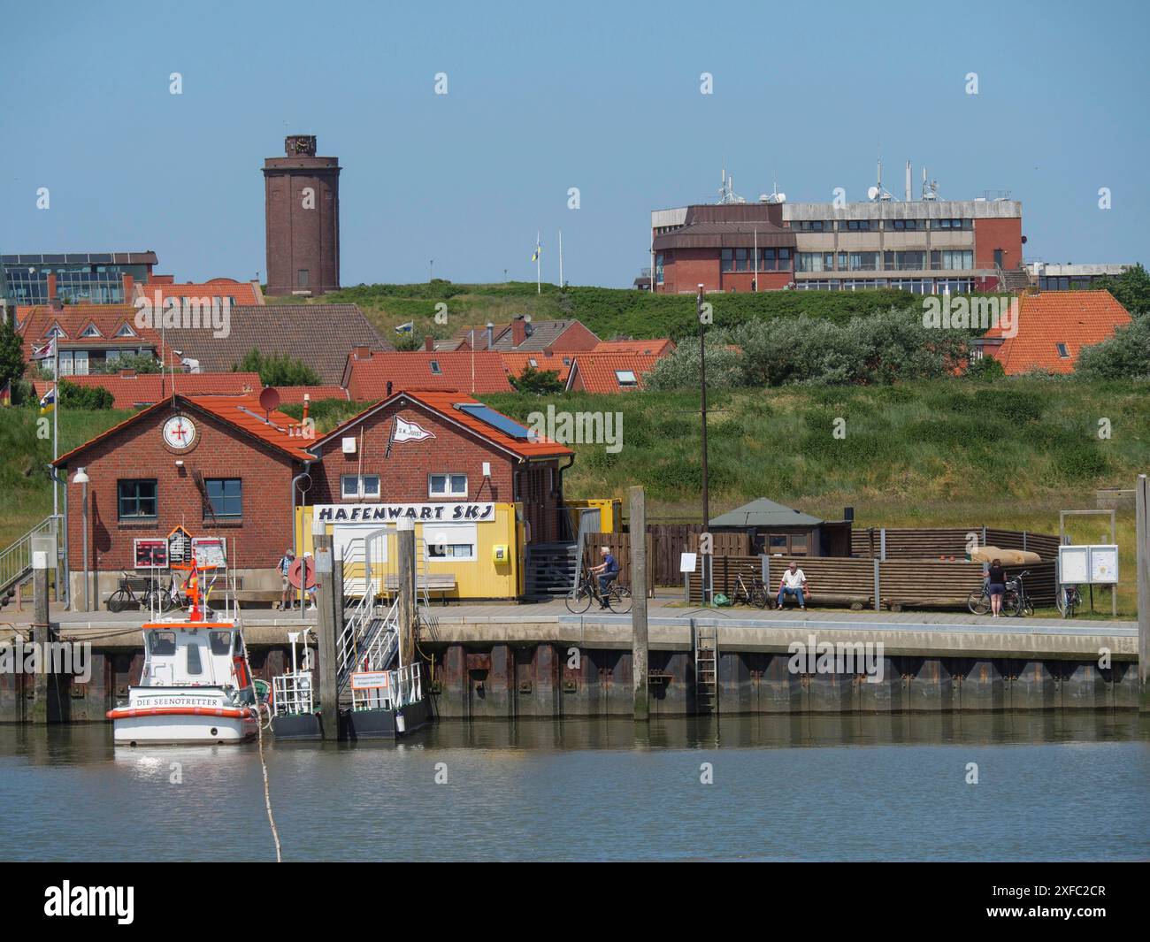 Zone côtière avec des bâtiments, des bateaux à la jetée et un mélange de bâtiments un peu plus anciens et plus modernes, juist, mer du Nord, allemagne Banque D'Images